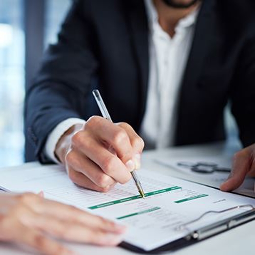 Man filling out paperwork at his desk.